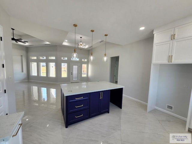 kitchen featuring marble finish floor, light countertops, open floor plan, white cabinetry, and blue cabinets