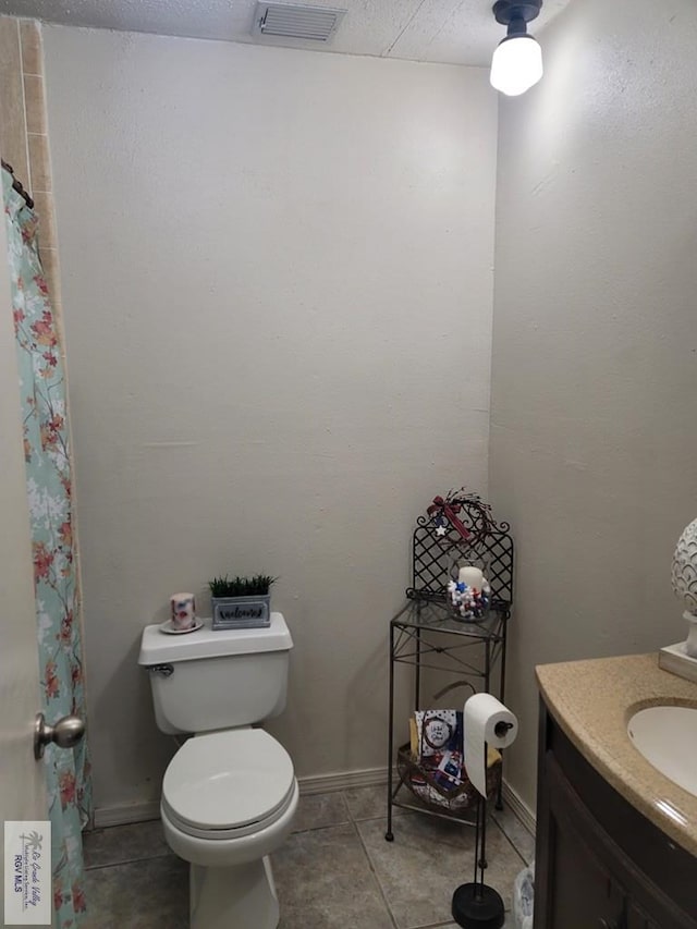 bathroom with tile patterned flooring, vanity, and toilet