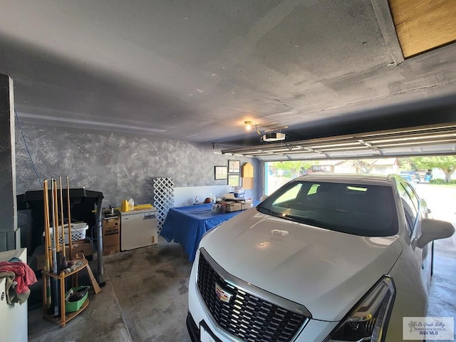 garage featuring a garage door opener and white refrigerator