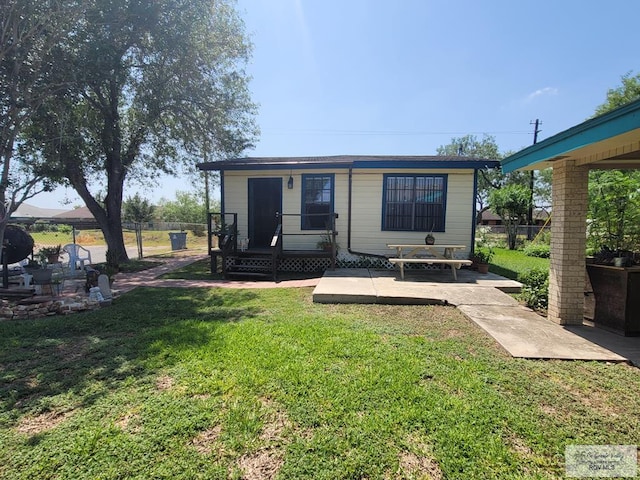 back of property with a yard and a patio