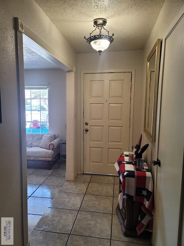 entryway with a textured ceiling and tile patterned floors