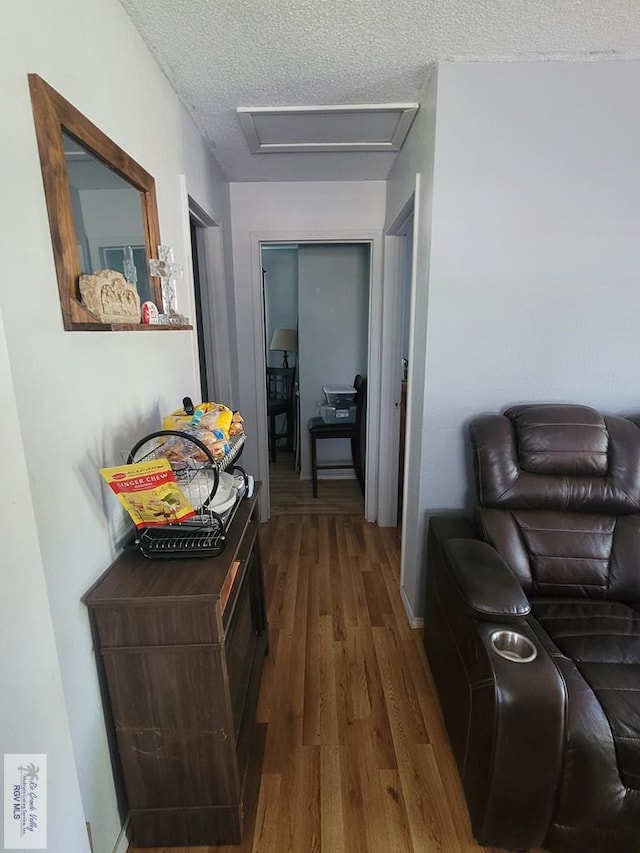 hall featuring a textured ceiling and hardwood / wood-style flooring