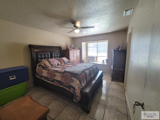 tiled bedroom featuring ceiling fan and a textured ceiling