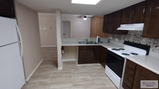 kitchen featuring dark brown cabinetry, ceiling fan, sink, white appliances, and decorative backsplash