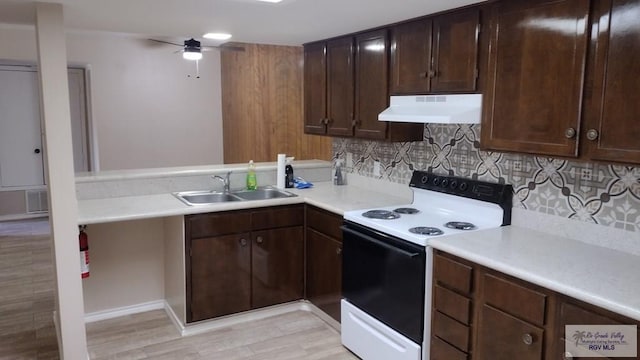 kitchen featuring decorative backsplash, sink, white electric range oven, and light wood-type flooring