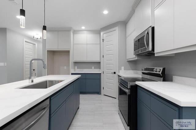 kitchen with blue cabinetry, stainless steel appliances, sink, and hanging light fixtures