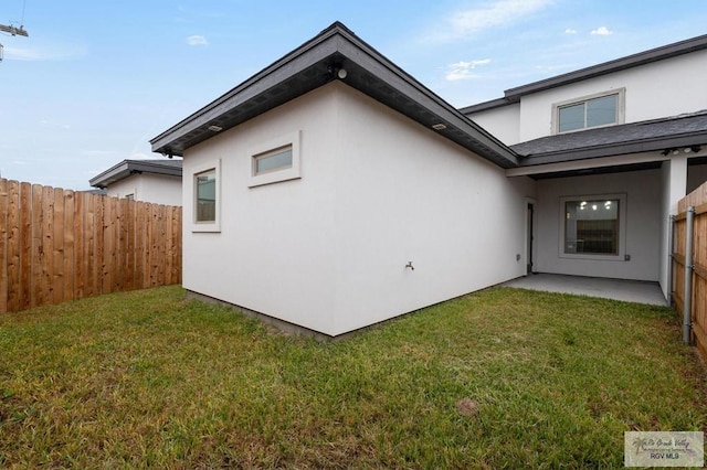 rear view of house featuring a patio area and a lawn