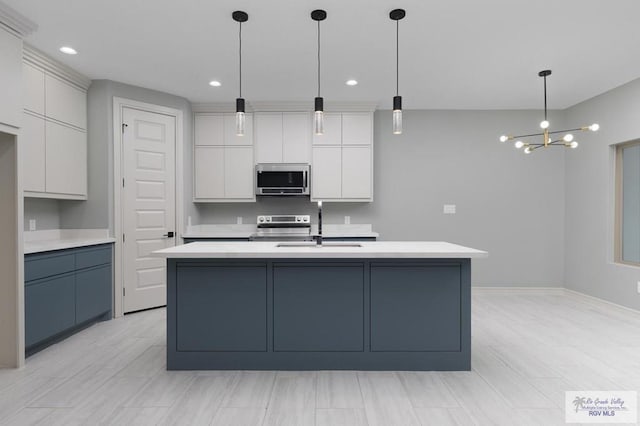 kitchen featuring sink, white cabinetry, a center island with sink, pendant lighting, and stainless steel appliances