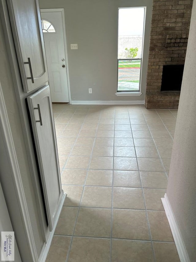 unfurnished living room featuring light tile patterned floors and a fireplace