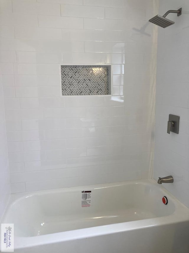 bathroom featuring tiled shower / bath