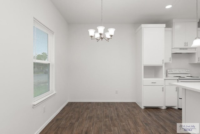 kitchen featuring electric range, white cabinets, hanging light fixtures, and dark hardwood / wood-style floors