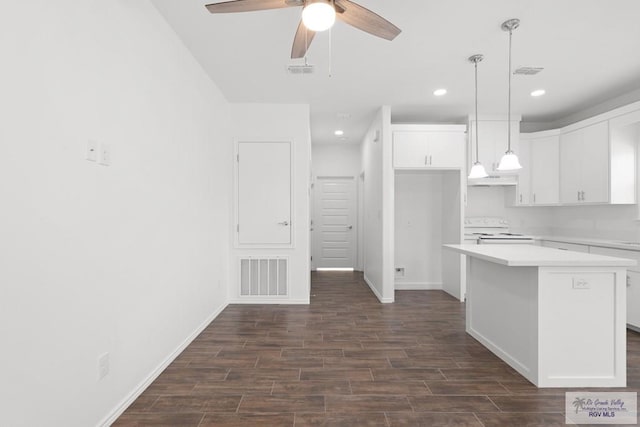 kitchen with ceiling fan, a center island, white electric range oven, dark hardwood / wood-style floors, and white cabinets