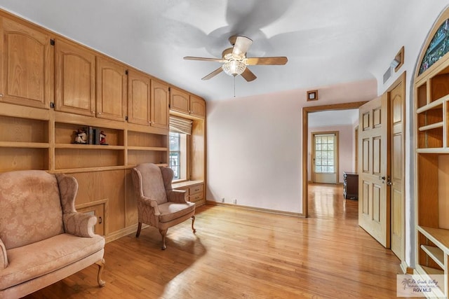 living area with light hardwood / wood-style floors and ceiling fan