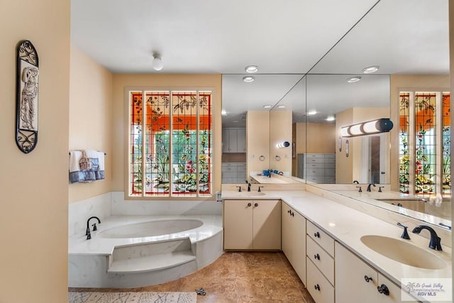 bathroom with vanity, a tub to relax in, and a wealth of natural light