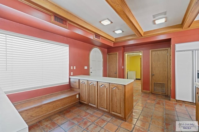 kitchen with crown molding, paneled refrigerator, beam ceiling, and kitchen peninsula