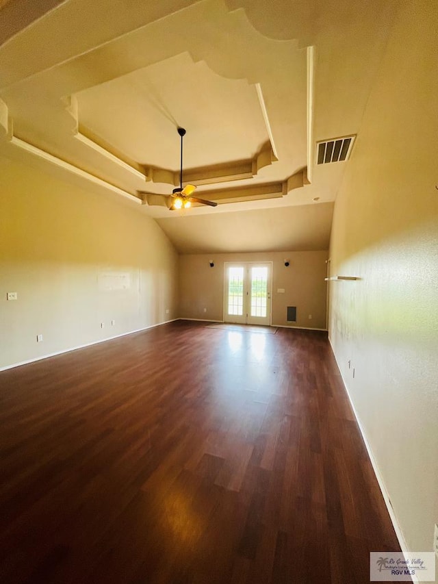 spare room featuring french doors, dark hardwood / wood-style floors, a raised ceiling, and ceiling fan