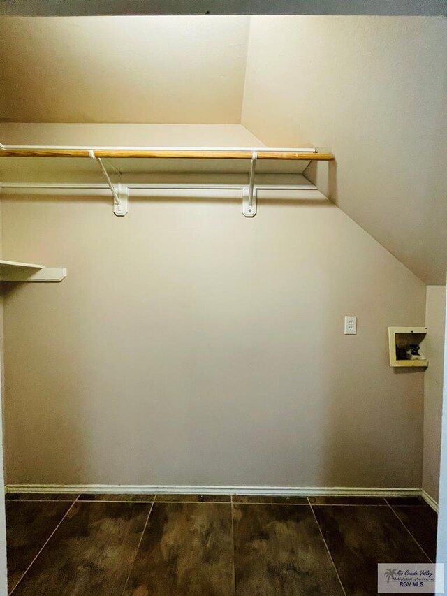 walk in closet featuring dark hardwood / wood-style flooring and lofted ceiling