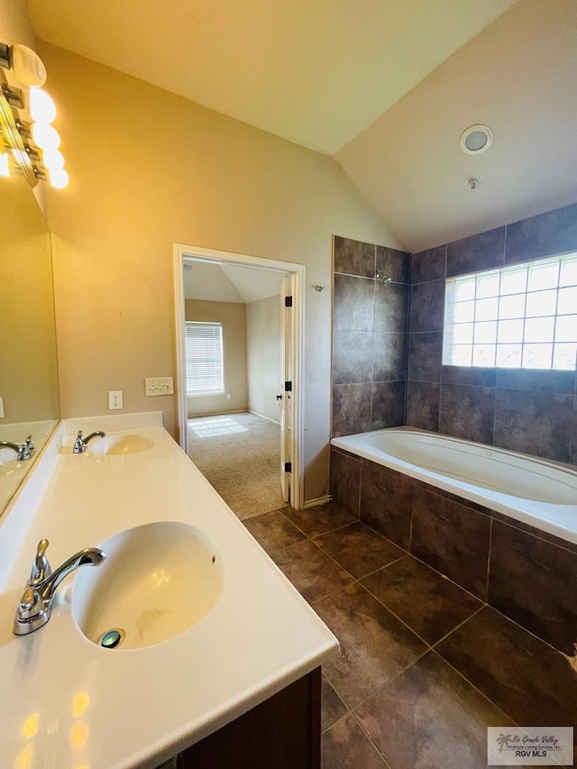 bathroom featuring tile patterned floors, vanity, and vaulted ceiling