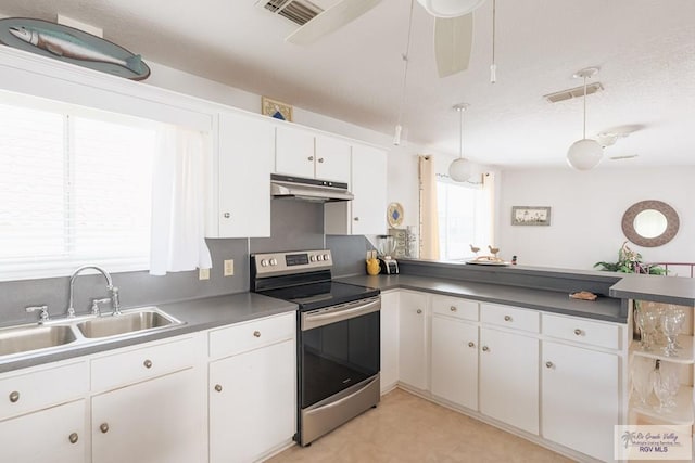 109 E Pompano St, South Padre Island, TX 78597 - kitchen with stainless steel range with electric cooktop, under cabinet range hood, white cabinetry, a peninsula, and decorative light fixtures