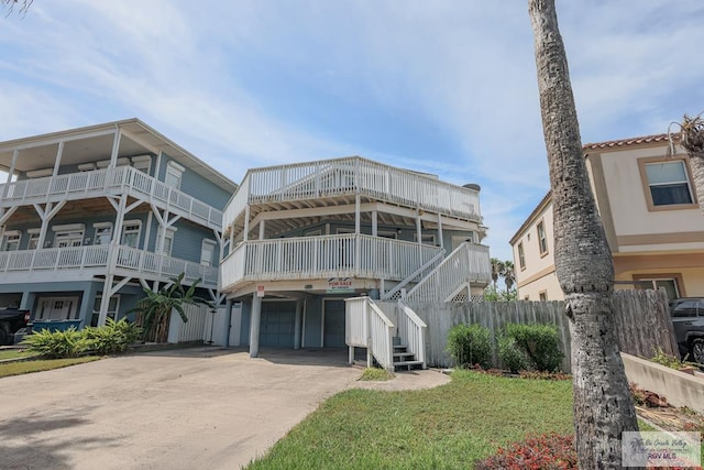 109 E Pompano St, South Padre Island, TX 78597 - rear view of property featuring driveway, stairway, a carport, and a garage