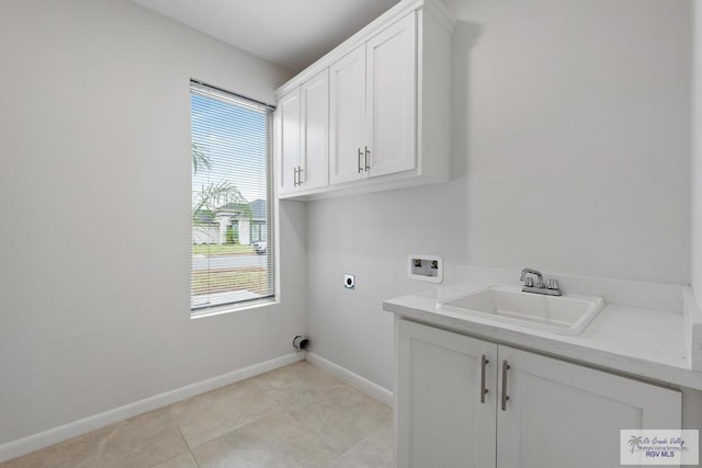 laundry room with cabinets, washer hookup, electric dryer hookup, sink, and light tile patterned floors