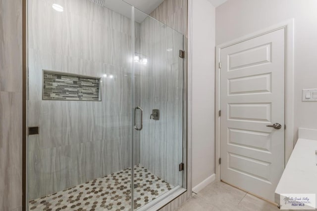 bathroom featuring tile patterned flooring, vanity, and walk in shower