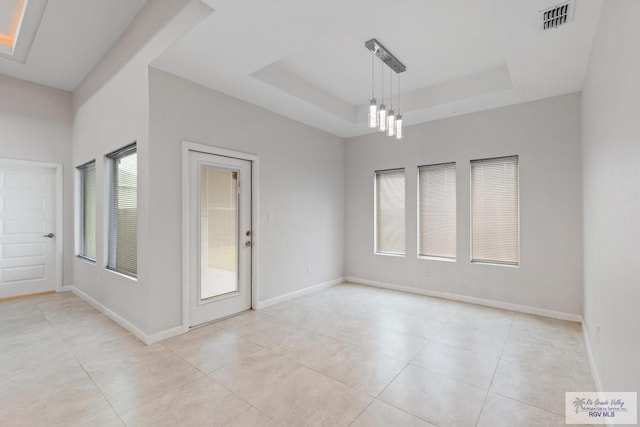 unfurnished room featuring light tile patterned floors, a raised ceiling, and a notable chandelier