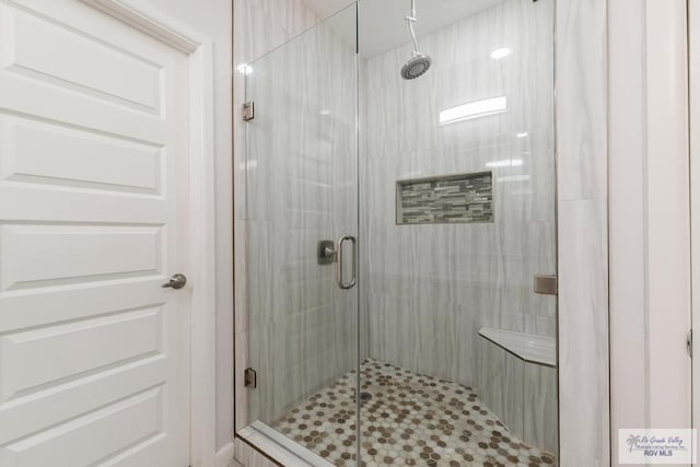 bathroom featuring a shower with shower door