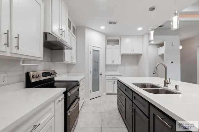 kitchen featuring stainless steel electric stove, sink, white cabinets, and pendant lighting