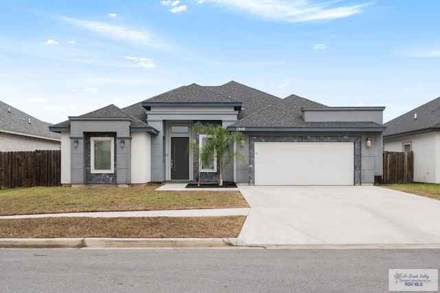 prairie-style house featuring a front lawn and a garage