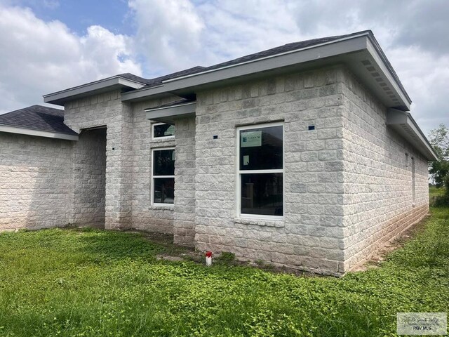 6692 Los Lobos Dr, Brownsville, TX 78521 - view of property exterior featuring a lawn and roof with shingles