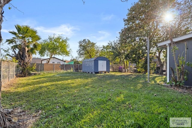 view of yard featuring an outbuilding, a fenced backyard, and a shed