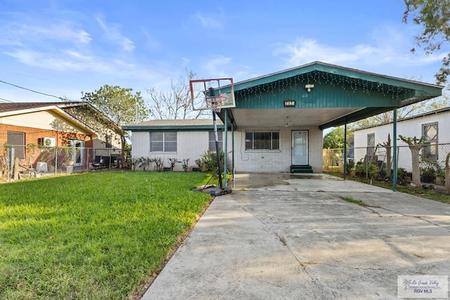 view of front of house with brick siding, fence, concrete driveway, a front yard, and a carport