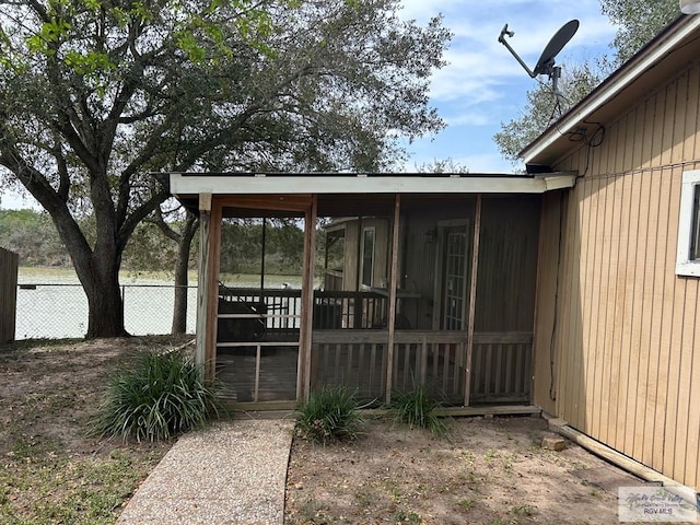 exterior space featuring fence and a sunroom