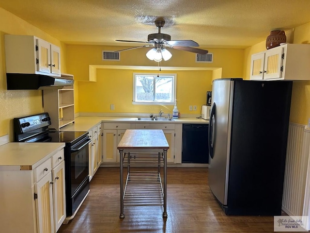 kitchen with visible vents, under cabinet range hood, light countertops, black appliances, and a sink