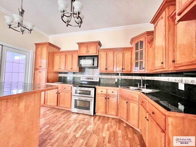 144 Country Club Rd Unit 1, Brownsville, TX 78520 - kitchen with a notable chandelier, ornamental molding, double oven range, and black microwave