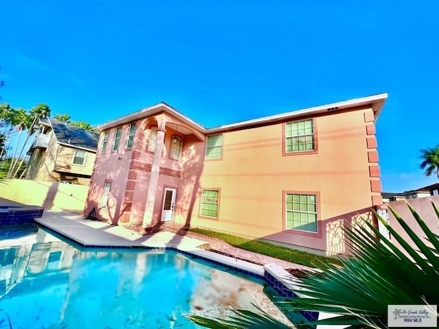 144 Country Club Rd Unit 1, Brownsville, TX 78520 - rear view of property with a fenced in pool, stucco siding, and fence