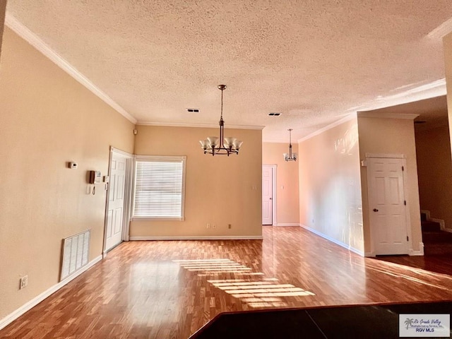 144 Country Club Rd Unit 1, Brownsville, TX 78520 - interior space with a textured ceiling, wood finished floors, an inviting chandelier, and visible vents