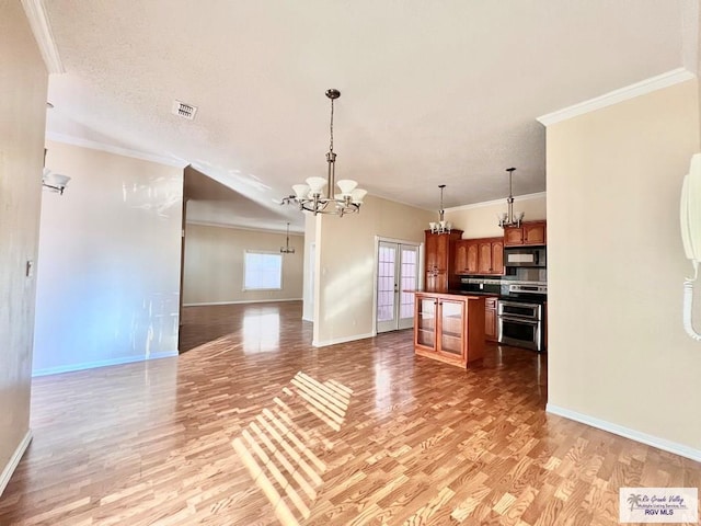 144 Country Club Rd Unit 1, Brownsville, TX 78520 - kitchen featuring open floor plan, a chandelier, black microwave, range with two ovens, and light wood-style flooring