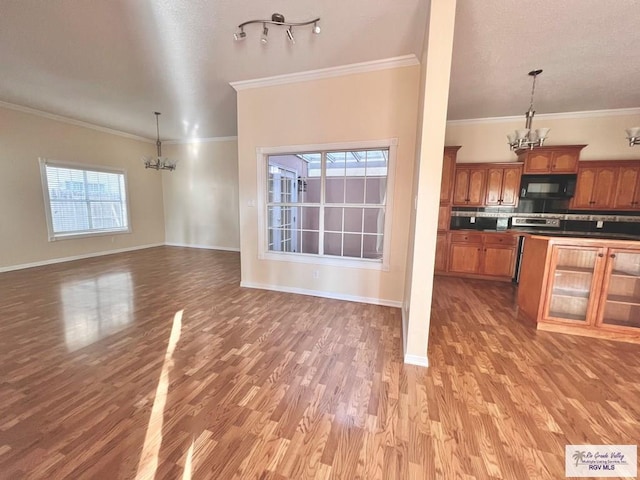144 Country Club Rd Unit 1, Brownsville, TX 78520 - unfurnished living room featuring ornamental molding, baseboards, a notable chandelier, and wood finished floors