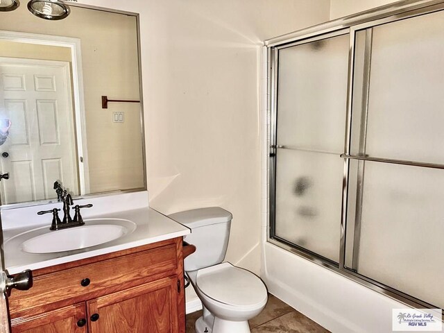 144 Country Club Rd Unit 1, Brownsville, TX 78520 - bathroom featuring toilet, enclosed tub / shower combo, vanity, and tile patterned flooring