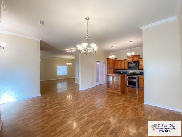144 Country Club Rd Unit 1, Brownsville, TX 78520 - kitchen featuring a chandelier, black microwave, double oven range, and open floor plan