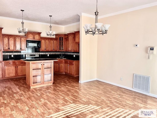 144 Country Club Rd Unit 1, Brownsville, TX 78520 - kitchen with tasteful backsplash, a notable chandelier, visible vents, and black microwave