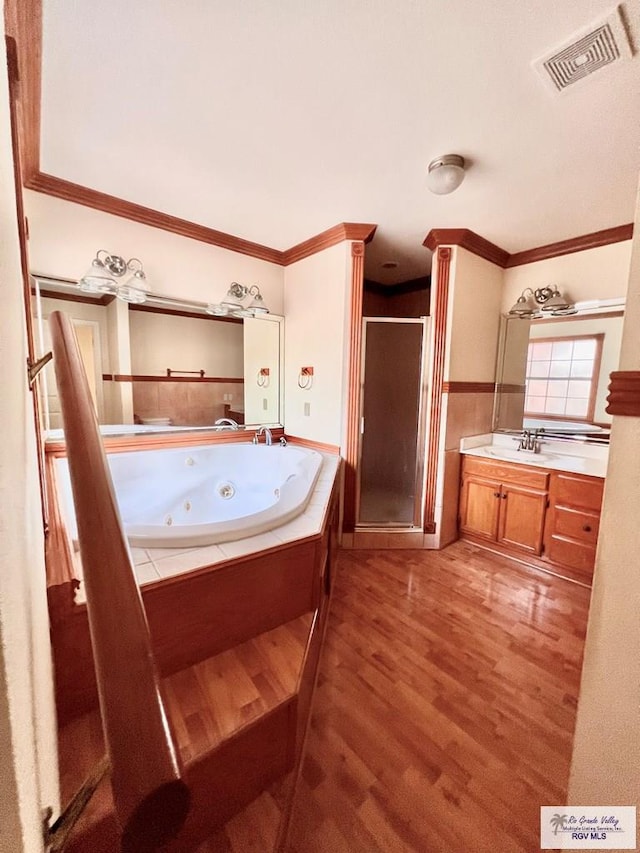 144 Country Club Rd Unit 1, Brownsville, TX 78520 - bathroom featuring a jetted tub, crown molding, a shower stall, visible vents, and wood finished floors