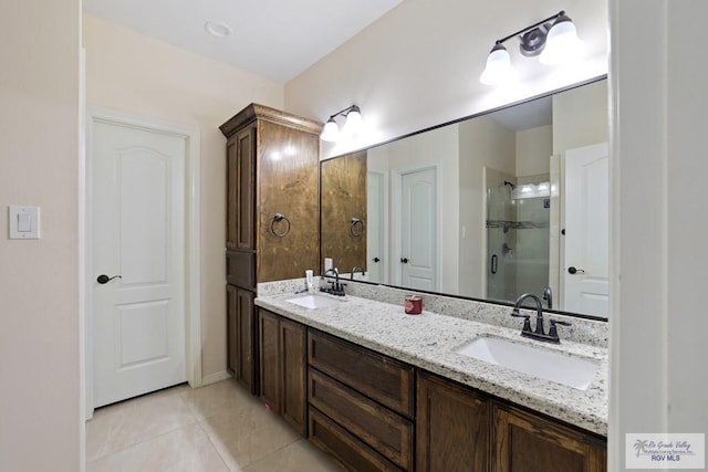 bathroom with double vanity, tile patterned flooring, a stall shower, and a sink