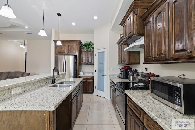 kitchen featuring a sink, stainless steel appliances, under cabinet range hood, light tile patterned floors, and light stone counters