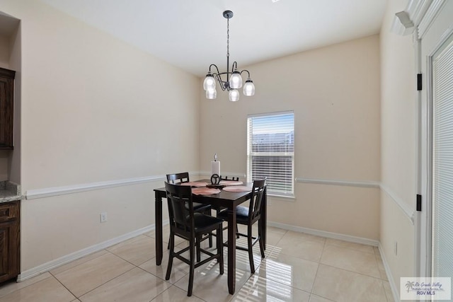 dining area featuring baseboards, light tile patterned floors, and a notable chandelier