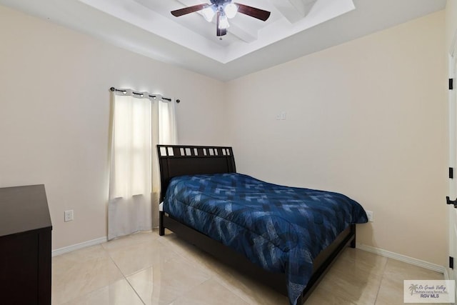 tiled bedroom with a tray ceiling and baseboards