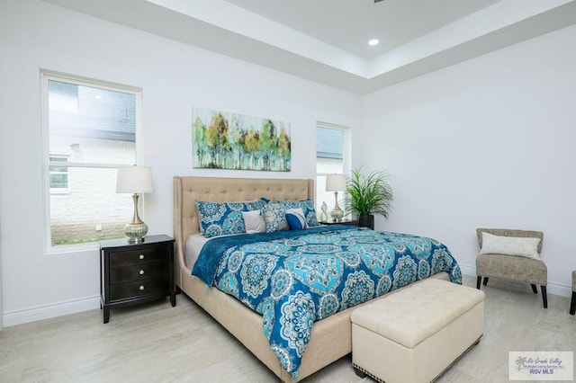 bedroom with light hardwood / wood-style floors and multiple windows