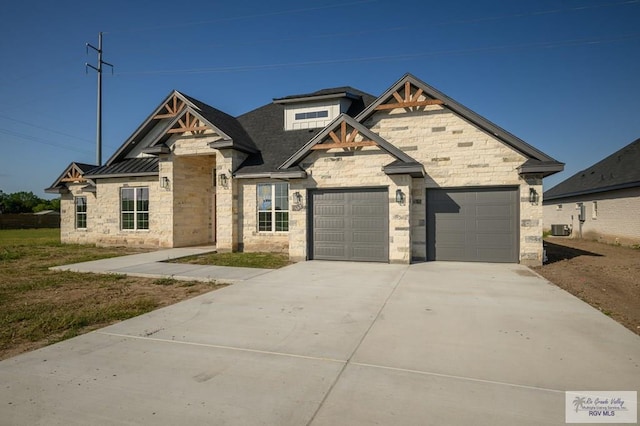 view of front of home featuring central AC unit and a garage